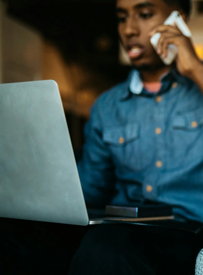a man sitting in a chair talking on a cell phone